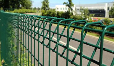 Green BRC top triangle bending welded wire metal fence along the highway.