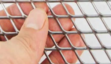 Galvanized iron expanded metal mesh in hand as sample.