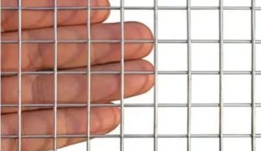 Galvanized iron welded wire mesh roll measure by hand.