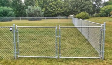Galvanized steel chain link fence in a yard.
