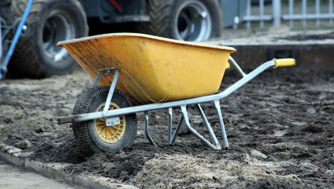 Wheelbarrow in the middle of a construction site's land.