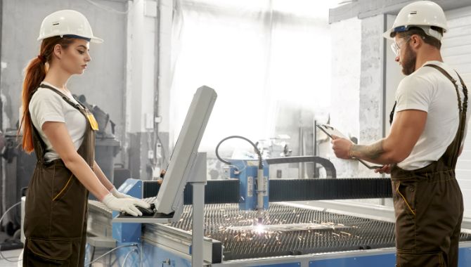 Wire mesh production in machine with workers.