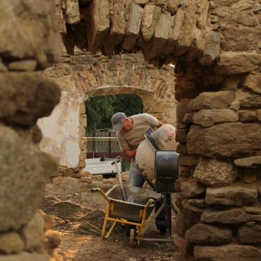 Worker using heavy duty wheelbarrow to carry debris.